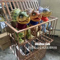Load image into Gallery viewer, Three colorful dinosaur-like puppets in a wooden cage with 'mesdino.com' branding.