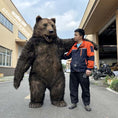 Load image into Gallery viewer, Person interacting with a large bear costume on a street.