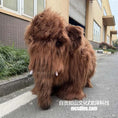 Load image into Gallery viewer, Brown furry creature on a street with buildings in the background