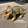 Load image into Gallery viewer, A realistic Triceratops dinosaur toy or prop sculpture standing on asphalt outdoors. The creature has textured olive-green and tan skin, a bony frill, and three front horns.