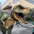 Bild in Galerie-Betrachter laden, Person in a dinosaur costume being pulled by a chain in an urban setting