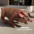 Load image into Gallery viewer, A realistic pig-shaped prop or costume figure with brown and red fur, shown outdoors on pavement with people and another animal in the background. A watermark reads mcsdino.