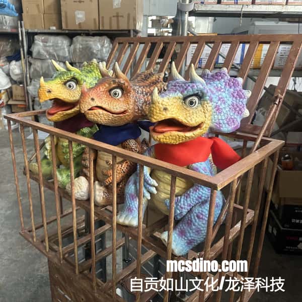 Four colorful dinosaur puppets in a wooden crate with 'mcsdino.com' branding.