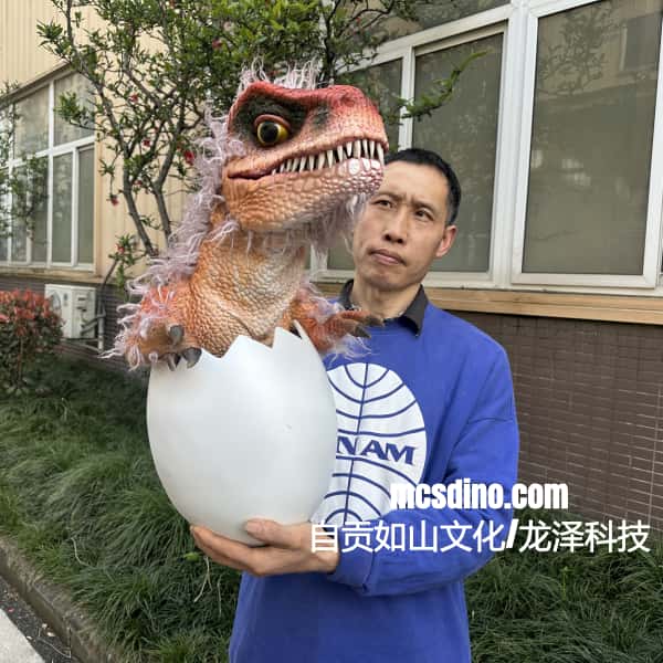 Person holding a dinosaur toy emerging from an egg with a building in the background