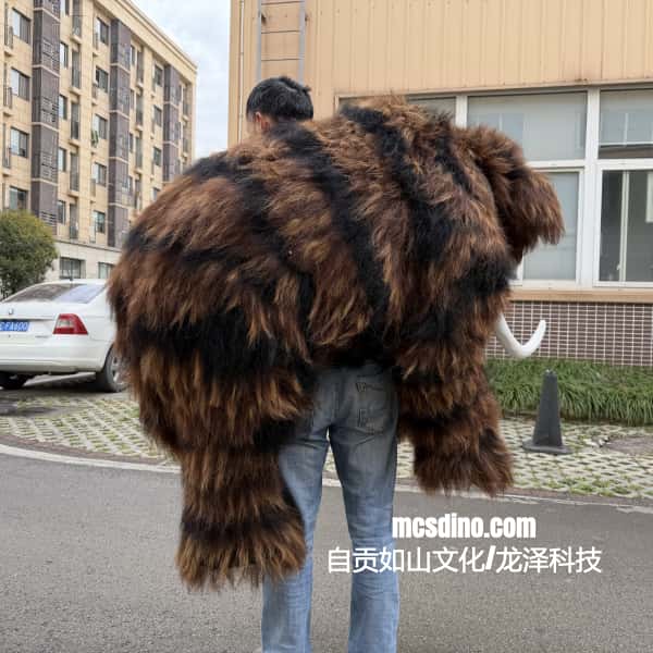 Person wearing a large, fluffy mammoth costume in an urban setting
