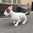 Load image into Gallery viewer, White dog-like creature with red circular marking on face in front of a building
