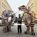Load image into Gallery viewer, Person in a parking lot with two large dinosaur costumes, one resembling a triceratops and the other a T-Rex.
