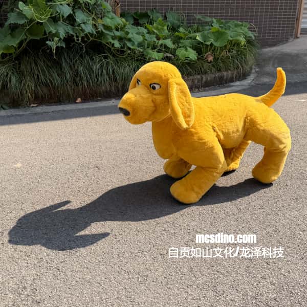 A yellow plush dog toy standing on an outdoor paved surface with green plants and a building wall in the background. White text at the bottom right reads 'mcsdino.