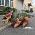 Cargar la imagen en la vista de la galería, Toy dinosaur model on a street with a building in the background
