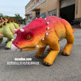Charger l'image dans la visionneuse de la galerie, Colorful dinosaur models on a street with a building in the background

