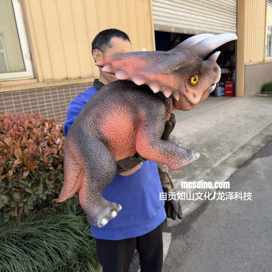 Person holding a large dinosaur toy outdoors