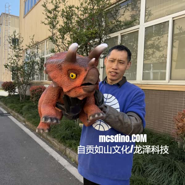 Person holding a dinosaur toy in front of a building