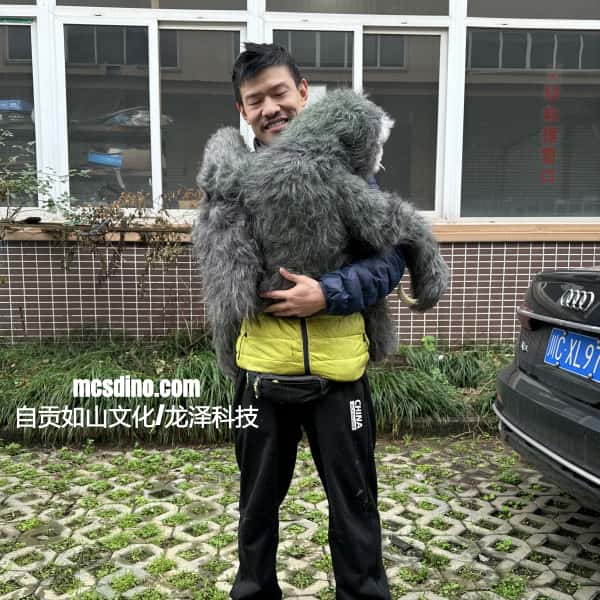 Person holding a large plush toy in front of a building with a car in the background