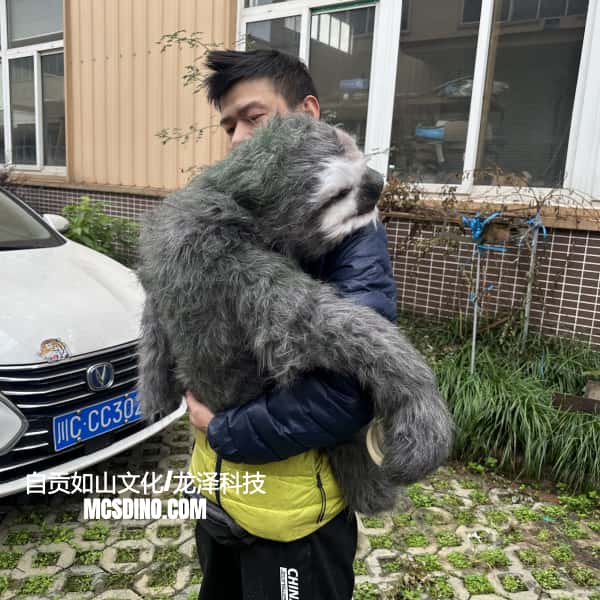 Person holding a large stuffed sloth in front of a car