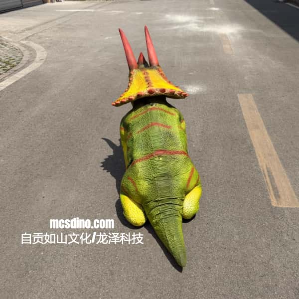 Dinosaur costume with red and yellow accents on a road