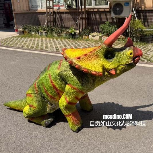 Colorful dinosaur toy on a street with a building and plants in the background