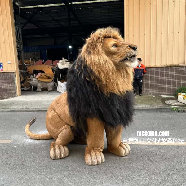 Large  lion suit sitting on a concrete surface with a building in the background.