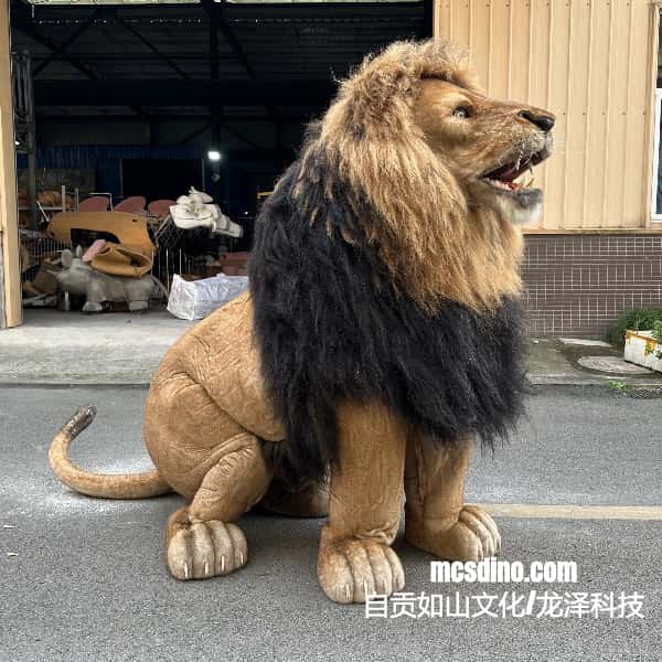 lion costume sitting on a concrete surface with a building and outdoor furniture in the background.