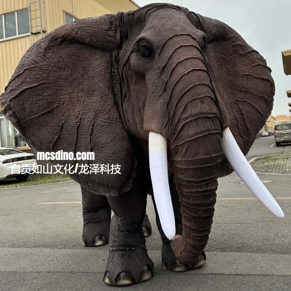 Large elephant costume on a street with buildings in the background