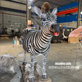Carica l'immagine nel visualizzatore della galleria, A zebra statue or animal sculpture displayed indoors in a workshop or showroom. The zebra has black and white stripes, large ears, and an open mouth showing a pink interior.
