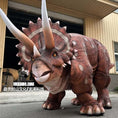 Load image into Gallery viewer, Dinosaur costume with large horns in front of a building
