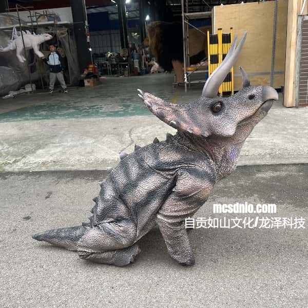 Dinosaur costume with a large head and frill in an indoor setting