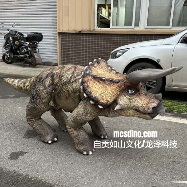 Dinosaur costume unitree GO2 walking on a street with a building and car in the background.