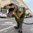 Bild in Galerie-Betrachter laden, Dinosaur costume on a person in an urban setting with buildings and cars in the background.
