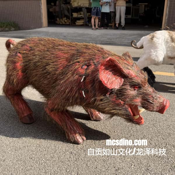 A realistic pig-shaped prop or costume figure with brown and red fur, shown outdoors on pavement with people and another animal in the background. A watermark reads mcsdino.